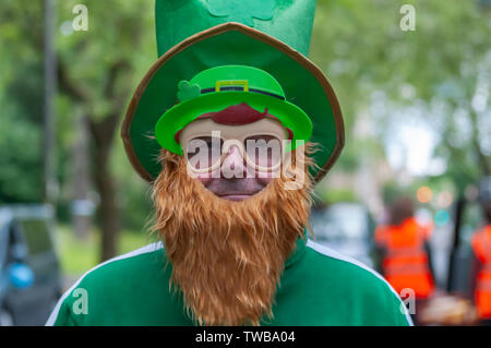 Glasgow, Scotland, Regno Unito. 19 giugno 2019. Un leprechaun fa la sua comparsa presso la Glasgow Taxi escursione a Troon che quest'anno celebra il 74º anniversario. Si tratta di una gita annuale dove oltre 100 tassisti della città si veste di costumi di fantasia, decorare il loro taxi e prendere più di 300 bambini con bisogni speciali in un giorno di viaggio per la città balneare di Troon. Credito: Berretto Alamy/Live News Foto Stock