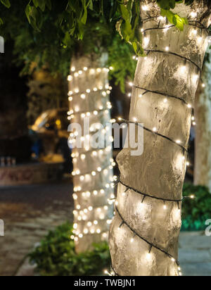 Alla moda di albero decorato con luci nella strada vicino al ristorante esterno zona nel cuore del centro cittadino di Atene Foto Stock