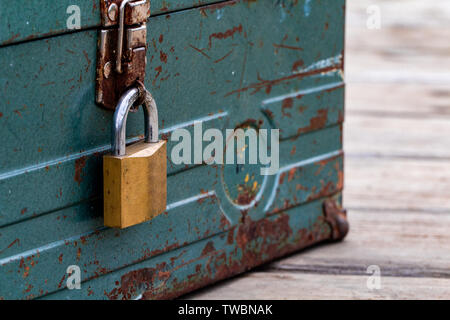 Vecchio arrugginito toolbox bloccato seduto su un legno Foto Stock