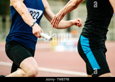 Staffetta uomini atleti corridori passando il testimone la concorrenza di atletica leggera Foto Stock