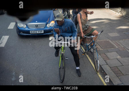 I ciclisti attendere che le spie di cambiare durante la guida lungo la Walworth Road a Southwark, il 15 giugno 2019, a Londra, in Inghilterra. Foto Stock