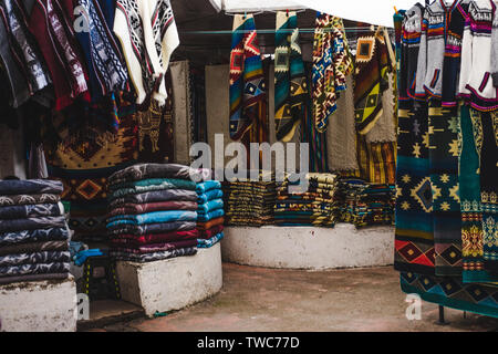 Affollate bancarelle alle popolazioni indigene di tessuto intessuto e negozio di souvenir in Otavalo, Ecuador, uno dei più grandi mercati artigianali in Sud America Foto Stock