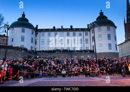 Turisti e folle locali di fronte al Palazzo Wrangel illuminato dal fuoco ardente, della vigilia di maggio Valborg celebrazioni personalizzate. Riddarholmen, Stoccolma, se Foto Stock