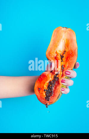 Dettaglio di una donna di spremitura a mano una papaia Foto Stock