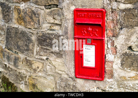 Un Rosso George VI UK Post Box Set in un muro di pietra Foto Stock