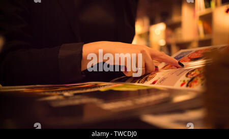 Ragazza sceglie il pasto dal menu del ristorante close-up Foto Stock