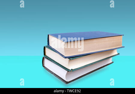 Libri impilati uno sull'altro e sfondo blu Foto Stock