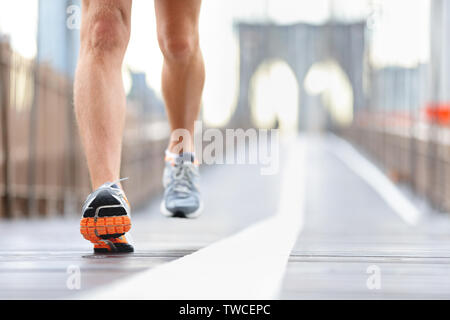 Scarpe da corsa, i piedi e le gambe close up runner jogging in azione e moto sul ponte di Brooklyn, New York City, Stati Uniti d'America Foto Stock
