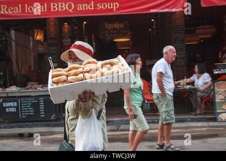 Siem Reapl, Cambogia - 30 Aprile 2013: donna ciambelle di vendita nel famoso pub street nel centro di Siem Reap. Foto Stock