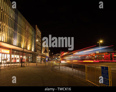 Bedford alla stazione degli autobus di notte con bus sfocata Foto Stock