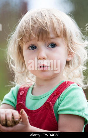 Piccolo bambino ragazza caucasica faccia closeup sul verde estate sfondo all'aperto Foto Stock
