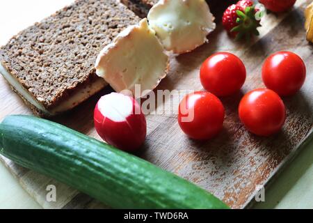 Chiudere la vista su una sana colazione tedesca con panini Pomodori Cetrioli e fragole Foto Stock