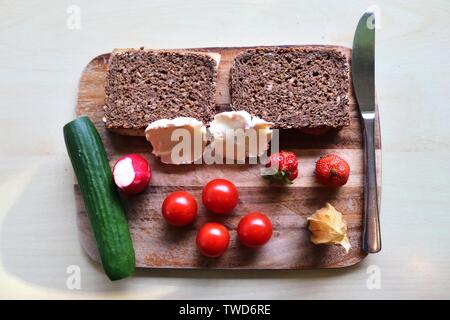 Chiudere la vista su una sana colazione tedesca con panini Pomodori Cetrioli e fragole Foto Stock