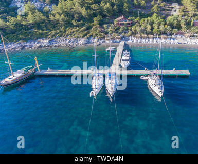 Piccolo molo con barche vicino alla spiaggia. Foto Stock