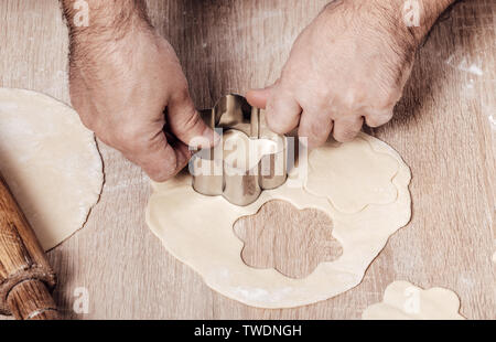 Uomo con stampo da forno per biscotti, mani closeup Foto Stock