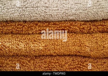 Pila di fogli piegati marrone e beige soffici asciugamani da bagno Foto Stock