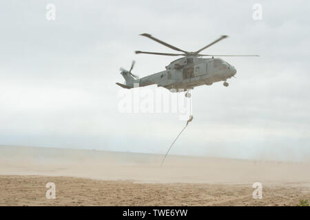 190616-N-MD802-1258 Klaipeda, Lituania (16 giugno 2019) Merlin MK 4 elicotteri da Royal Navy Commando forza elicottero sbarcare Royal Marines di commando 45 tramite fune fast come parte di un assalto anfibio per esercitare le operazioni del Baltico (BALTOPS) 2019. BALTOPS è il premier marittima annuale di esercizio focalizzato nella regione del Mar Baltico, segnando il quarantasettesimo anno di uno degli esercizi più grande nel Nord Europa e aumentare la flessibilità e interoperabilità tra alleati e partner delle nazioni. (U.S. Foto di Marina di Massa lo specialista di comunicazione di terza classe Jack D. Aistrup/rilasciato) Foto Stock