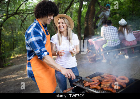 I giovani di sesso maschile e femminile giovane la cottura barbecue in natura Foto Stock