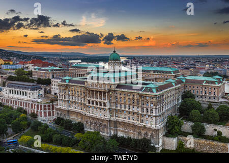 Budapest, Ungheria - vista aerea del bellissimo Castello di Buda Palazzo Reale al tramonto con il Palazzo del Parlamento e la skyline di Budapest a sfondo Foto Stock