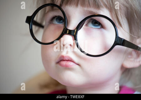 Grave bambini bianchi ragazza in grandi bicchieri nero faccia closeup ritratto Foto Stock