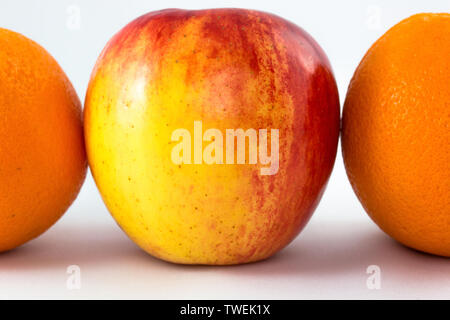 La linea orizzontale di mele rosse con mezza arancia. Foto Stock