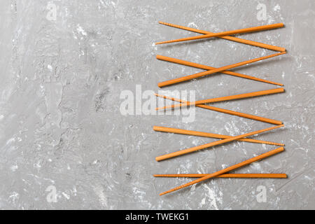 Molte le bacchette di bambù sul cemento nero lo sfondo di pietra, vista dall'alto con copia spazio. un sacco di sushi si inceppa nella forma di un ornamento. Foto Stock