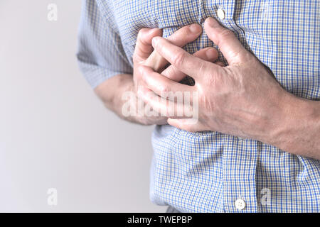 Il giovane uomo è che soffrono di dolore al petto. Spasmo del torace, angina pectoris. Attacco cardiaco Foto Stock