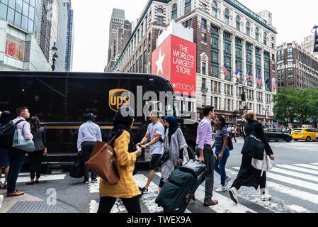 La città di New York, Stati Uniti d'America - 31 Luglio 2018: Persone che attraverso un passaggio pedonale di fronte Macys mentre un UPS azienda di trasporti carrello guida in M Foto Stock