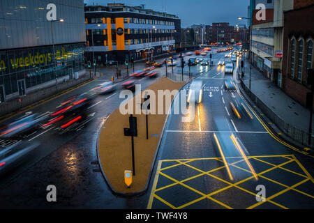 Lo spostamento del traffico lungo umide strade di città di Leicester, quando scende la notte. Foto Stock