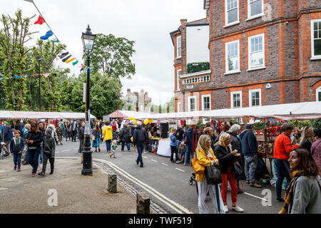 La folla che frequentano le arti e le bancarelle di artigiani in fiera in piazza, un festival annuale di Highgate Village, London, Regno Unito Foto Stock