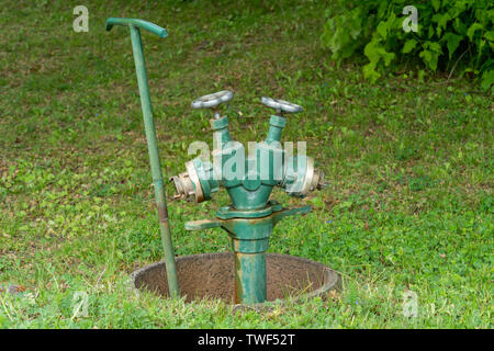 Professional sistema di irrigazione per il verde pubblico e parchi costituito da toccando due volte il punto e il tubo flessibile di acqua per irrigazione di grandi aree di piante o Foto Stock