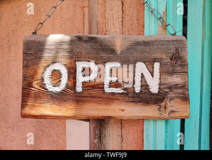 Open Text sul cartello in legno bordo impiccato con una catena di metallo su una facciata degli edifici, vista ravvicinata Foto Stock