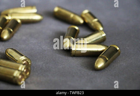 Close up di 9 mm pistola dorata proiettili munizioni sullo sfondo. Forza speciale unità. Foto Stock
