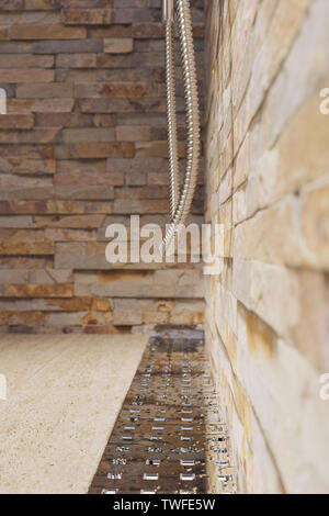 3D rendering di gocce d'acqua sulla canalina metallica del piatto doccia con piastrelle di pietra naturale Foto Stock