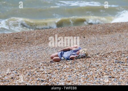 Hastings, East Sussex, Regno Unito. 20 GIU, 2019. Regno Unito: meteo soleggiate di Hastings sulla costa sud est con temperature nella regione di 18C. Una donna prende un pisolino sulla spiaggia in un caldo e assolato pomeriggio. ©Paolo Lawrenson 2019, Photo credit: Paolo Lawrenson/Alamy Live News Foto Stock