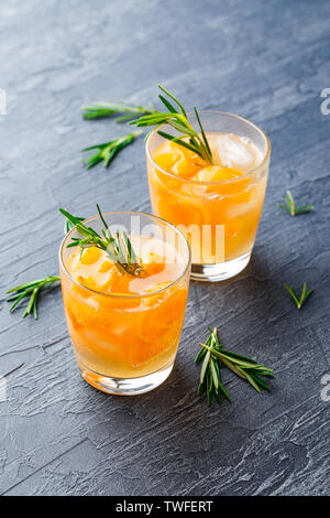 Bibite estive, rosmarino aprcot cocktail con ghiaccio in bicchieri. Estivo rinfrescante in casa bevande alcoliche o analcoliche cocktailsor Detox infuso aromatizzati Foto Stock