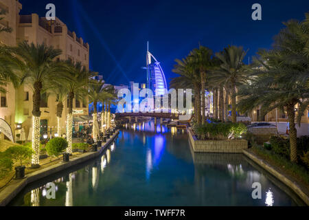 Il Burj al Arab è illuminato in fasci di luce nel Souk Madinat Jumeirah. Foto Stock