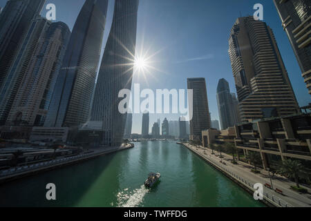 Sun arrivando fino al di sopra del flussi di Dubai la luce in marina. Foto Stock