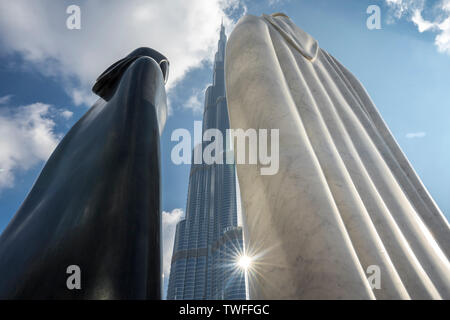 Il grazioso statue di un Arabo giovane telaio il Burj Khalifa a Dubai. Foto Stock