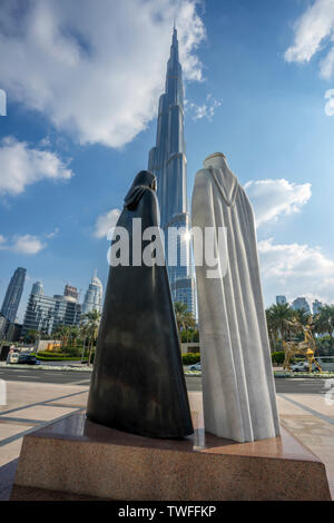 Il grazioso statue di un Arabo giovane telaio il Burj Khalifa a Dubai. Foto Stock