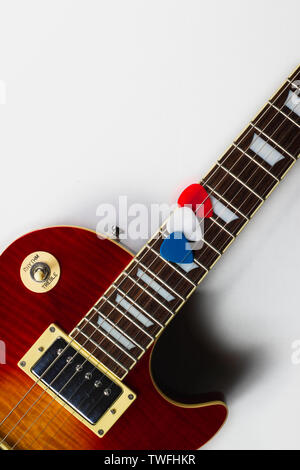 Les Paul style chitarra elettrica con rosso, bianco e blu picks. I colori di rendere l'immagine patriottici per il 4 di luglio. La chitarra ha una ciliegia sunb Foto Stock