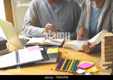 Gli studenti amico aiuta l insegnamento e l apprendimento oggetto ulteriori nella libreria. Il concetto di istruzione. Foto Stock