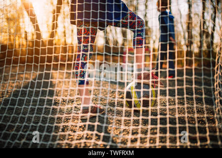 Due bambini di giocare a calcio al tramonto, Stati Uniti Foto Stock