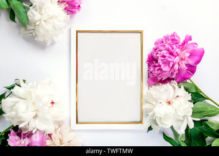 Bianca e oro telaio in legno decorate con fiori di peonie. Mockup, vista dall'alto, lo sfondo dello spazio Foto Stock