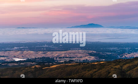 Le nuvole e la nebbia al crepuscolo su Silicon Valley e l'area della baia di San Francisco; Università di Stanford visibile sotto uno strato di nubi; Mt Diablo in b Foto Stock