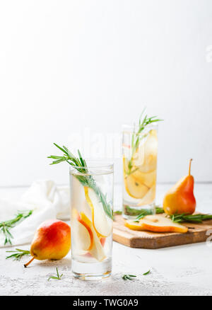 Bibite estive, rosmarino pera cocktail con ghiaccio in bicchieri. Estivo rinfrescante in casa bevande alcoliche o analcoliche cocktailsor Detox infuso aromatizzati w Foto Stock