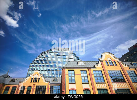 Un edificio storico di una ex casa di stampa e la facciata di un moderno edificio di uffici a Poznan Foto Stock
