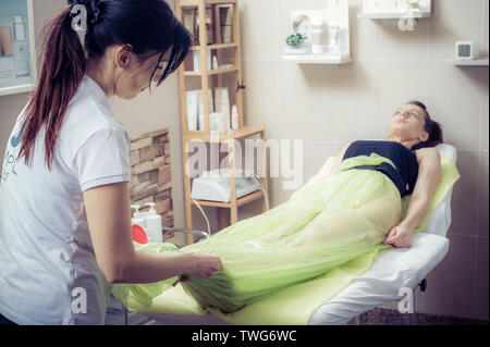 Giovane donna nel salone di bellezza di essere preparati per il corpo vuoto anti cellulite la terapia Foto Stock