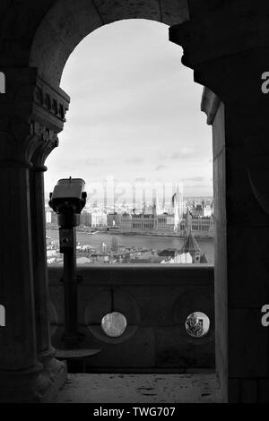 Vista attraverso un arco al Bastione del Pescatore, sulla parte di Buda, del fiume Danubio, la Casa del Parlamento e dal lato di Pest della città. Foto Stock