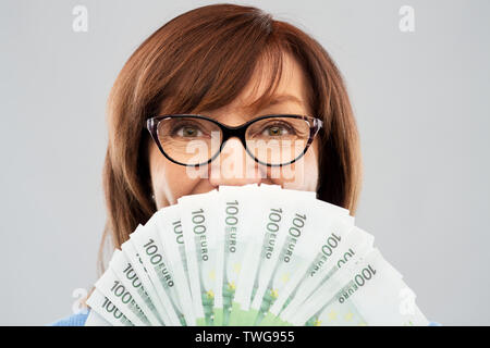 Senior donna con centinaia di euro banconote denaro Foto Stock